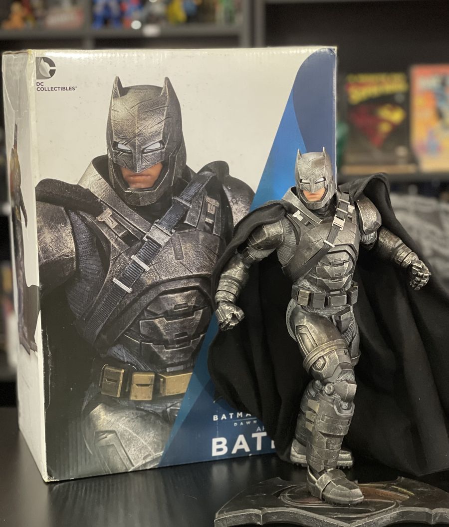 Figura do Batman de armadura da DC Collection ao lado da caixa